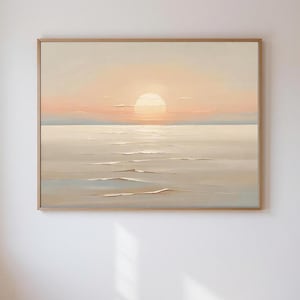 Puede incluir: Pintura enmarcada de un paisaje marino con puesta de sol. El sol es un círculo grande y brillante en un cielo color melocotón. El océano está en calma, con suaves olas en tonos beige y azul.
