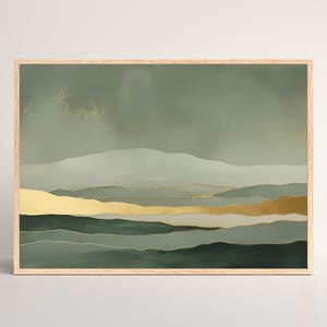 May include: Abstract landscape art print in a wooden frame. The artwork features layers of green and gold tones, depicting rolling hills and mountains under a muted sky. The gold accents add a touch of elegance to the nature-inspired design.