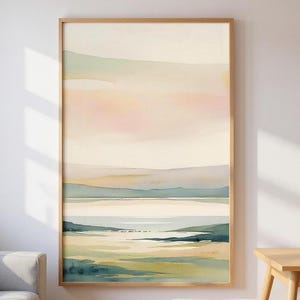 Peut inclure: Impression d'art de paysage abstrait dans un cadre en bois naturel. La peinture à l'aquarelle présente des couleurs pastel douces, dont le rose, le beige et le bleu, représentant une scène côtière sereine. L'œuvre évoque le calme et la tranquillité.