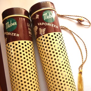 May include: A white ceramic mug with a black handle and the text "But First, Coffee" in a handwritten style. The mug is on a white surface. The mug is approximately 4 inches tall.