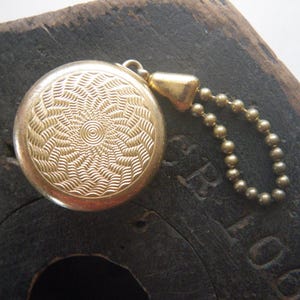 May include: A white ceramic mug with a black handle and the text "But First, Coffee" in a bold, black font. The mug is filled with a dark liquid, likely coffee, and sits on a light-colored surface.