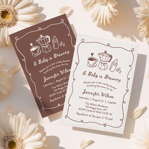 May include: Two baby shower invitations with a coffee theme. The text "A Baby is Brewing" is displayed with illustrations of a coffee cup, a moka pot, and a baby bottle. The invitations are brown and off-white with a decorative border.