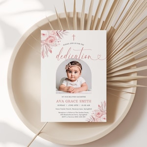 May include: A dedication announcement card featuring a baby's photo, floral accents, and the text "dedication." The card includes event details: date, time, location, and RSVP information. The design is soft with pink and beige tones.