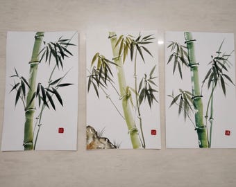 May include: A set of three vertical watercolor paintings on white paper, each depicting green bamboo stalks with dark green leaves. The paintings feature varying compositions of bamboo and include a small red square seal stamp in the bottom corner.