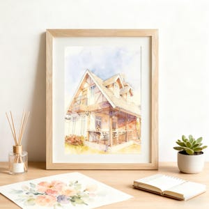 May include: Watercolour painting of a house in a light wood frame. The house features a balcony and a porch with a table and chairs. The painting is in a light style with soft colours.