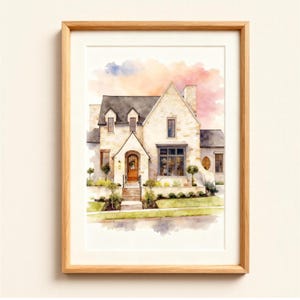 May include: A watercolour painting of a house with a light stone exterior, dark roof, and a wooden door. The artwork is framed in a light wood frame. The sky has pink, orange, and blue hues.