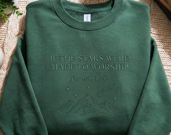 Puede incluir: Sudadera verde oscuro con la frase en relieve "IF THE STARS WERE MADE TO WORSHIP so will i" y un diseño de montaña y estrellas. La sudadera, de cuello redondo, está hecha de un tejido suave.