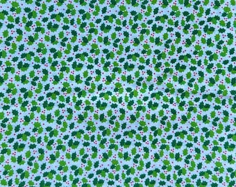 May include: A fabric with a repeating pattern of green holly leaves and small red berries on a white background. The leaves vary in shades of green, creating a textured appearance. This festive design is suitable for holiday-themed crafts and decor.