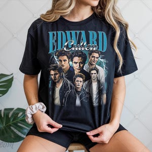 Puede incluir: Camiseta negra con un gráfico de Edward Cullen y otros personajes de la saga Crepúsculo. El diseño incluye el nombre "Edward Cullen" en una fuente azul de estilo vintage, con un efecto de rayo.
