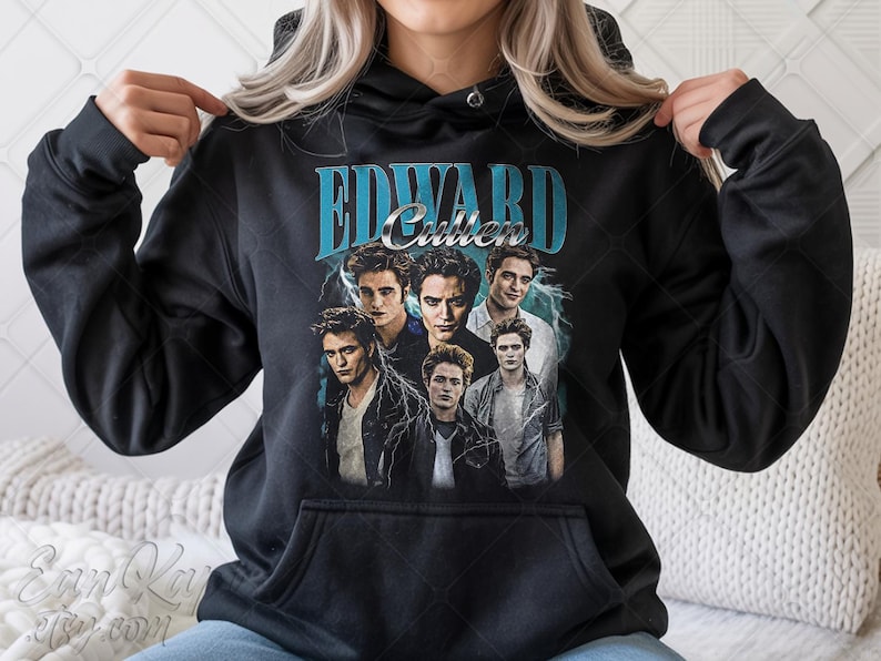 May include: Black hooded sweatshirt featuring a graphic of Edward Cullen from the Twilight series. The design includes the name "Edward Cullen" in teal lettering above a collage of images of the character. The sweatshirt has a front pocket.