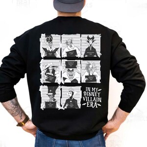 May include: Black sweatshirt featuring a grid of Disney villains in mugshot style. Each villain holds a sign with their name and year. The text "IN MY DISNEY VILLAIN ERA" is printed below the grid in white.