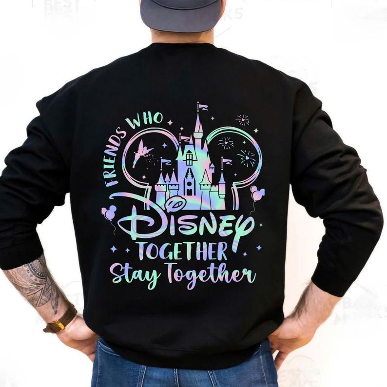 May include: Black sweatshirt with a colorful graphic featuring a castle, Mickey Mouse ears, and the words "Friends Who Disney Together Stay Together." The design has a holographic effect. The sweatshirt has long sleeves.