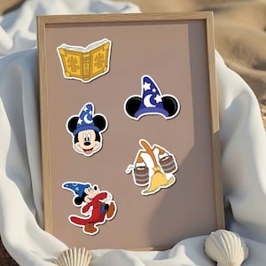 May include: A collection of colorful Disney-themed stickers featuring Mickey Mouse in a wizard hat, a wizard hat with stars and a crescent moon, a golden book, and a broom carrying buckets. The stickers are on a brown background.