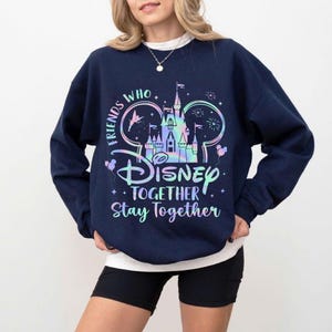 May include: Navy blue sweatshirt with a colorful Disney castle graphic and the text "Friends Who Disney Together Stay Together." The design includes Mickey Mouse ears, stars, and balloons. The sweatshirt is a crew neck style.