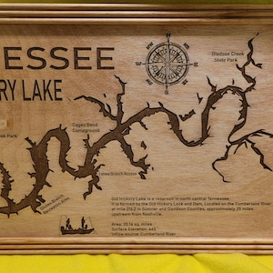 May include: A wooden plaque with an engraved map of Old Hickory Lake in Tennessee. The plaque includes the lake's name, "Tennessee Old Hickory Lake", and a compass rose. The map shows the lake's shape, surrounding areas, and a description of the lake's history and features.