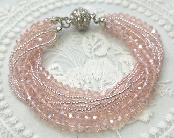 Multi strand beaded bracelet in beautiful light pink with crystal ball magnetic clasp.