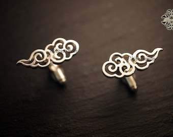 Puede incluir: Un par de gemelos de plata con un diseño delicado e intrincado de nubes. Los gemelos están hechos de plata pulida y tienen un aspecto clásico y elegante.