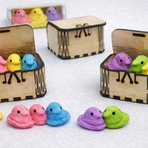 olorful marshmallow chicks are displayed with small wooden craft boxes, showing how versatile these boxes are for decorating, filling, and gifting. Their smooth laser‑cut design makes them fun for kids’ crafts, party favors, and creative holiday projects, turning simple treats into charming, personalized gifts.