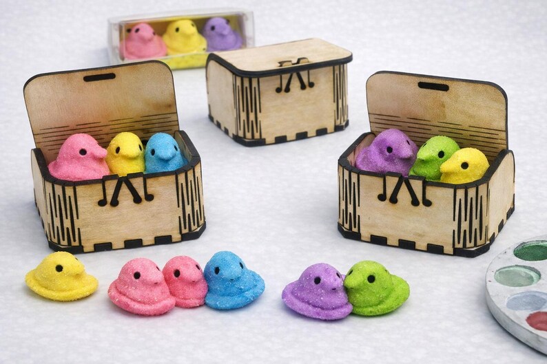 olorful marshmallow chicks are displayed with small wooden craft boxes, showing how versatile these boxes are for decorating, filling, and gifting. Their smooth laser‑cut design makes them fun for kids’ crafts, party favors, and creative holiday projects, turning simple treats into charming, personalized gifts.
