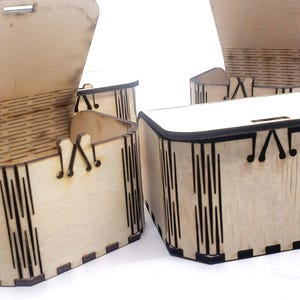 A small wooden craft box with laser‑cut details sits ready to decorate, showing the smooth unfinished wood that makes these boxes perfect for DIY kits. Their simple shape invites painting, stickers, and creative designs, making them ideal for kids’ crafts, party activities, and personalized gifts that feel handmade and meaningful.