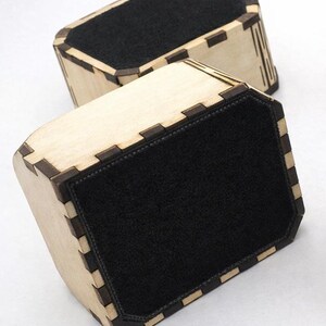 Two handcrafted wooden box bottoms shown flipped over to display their smooth black felt backing. The laser‑cut joints, light natural wood, and precise inset felt highlight the quality and care in the construction. Felt protects surfaces from scratches and adds a polished, finished look to the boxes.