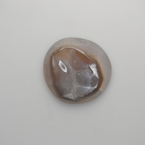 May include: A smooth, gray and brown agate stone with a unique, naturally formed pattern.