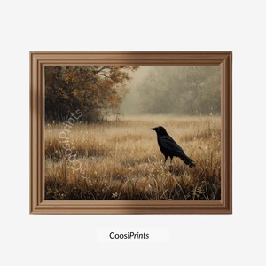 Könnte beinhalten: Ein gerahmter Kunstdruck, der eine schwarze Krähe in einem goldbraunen Grasfeld an einem nebligen Morgen zeigt. Im Hintergrund sind Bäume mit herbstlich gefärbtem Laub zu sehen. Der Text CoosiPrints ist deutlich erkennbar.