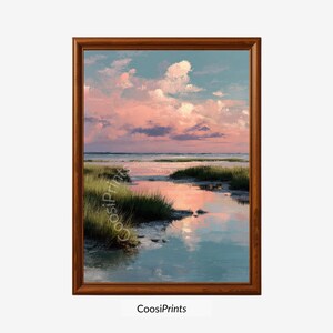 Könnte beinhalten: Gerahmtes Landschaftsgemälde, das eine Küstenlandschaft zeigt. Das Kunstwerk zeigt einen Sonnenuntergang mit rosa und blauen Farbtönen, die sich im Wasser spiegeln. Grünes Marschgras säumt den Wasserrand, und der Himmel ist mit flauschigen Wolken gefüllt. Der Rahmen besteht aus dunkelbraunem Holz.