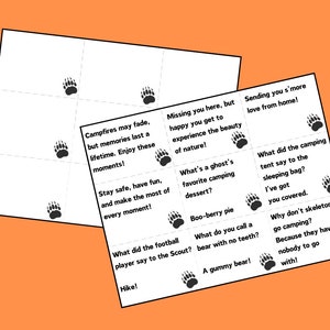 May include: A set of 12 camping-themed cards with paw prints and text. The cards feature questions and answers about camping, such as "What did the football player say to the Scout?" and "Hike!"