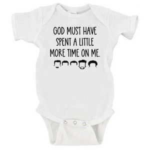 May include: White baby onesie with black text that reads "God must have spent a little more time on me."  Five black silhouettes of men's heads are below the text.