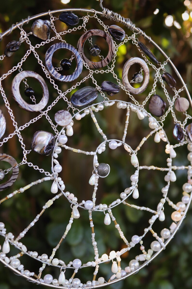 Mermaid inspired spiral wall hanging with nautical shell details and silver charm centre.