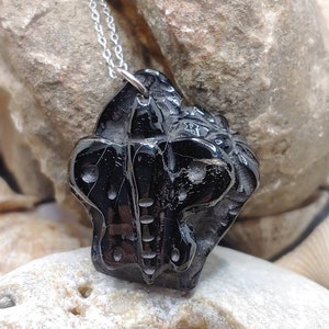 May include: A black onyx pendant necklace featuring a detailed carved butterfly design. The pendant is attached to a silver chain.