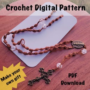 May include: A brown crochet rosary with clear beads and a decorative cross. The rosary is displayed on a white card with the text "Crochet Digital Pattern". The image also includes the text "Make your own gift" and "PDF Download".