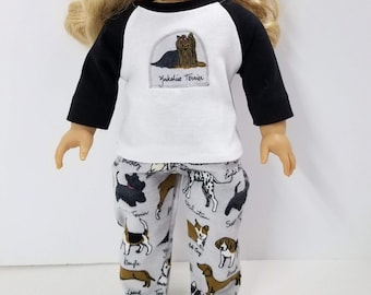 May include: A white and black raglan t-shirt with a Yorkshire Terrier graphic and the text "Yorkshire Terrier". The t-shirt is paired with gray pants featuring a variety of dog breeds.