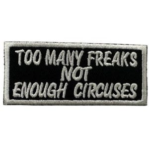 May include: Black rectangular patch with white embroidered text that reads "TOO MANY FREAKS NOT ENOUGH CIRCUSES". The patch has a white border and is likely designed to be sewn or ironed onto clothing or accessories.
