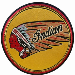 May include: Embroidered patch featuring a Native American profile in red, brown, and blue, wearing a feathered headdress. The word "Indian" is written in a stylized font. The patch has a yellow background with red and black borders.