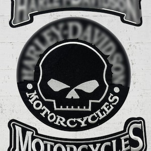 May include: Black and white Harley-Davidson Motorcycles patch with a skull design. The patch features the Harley-Davidson logo at the top and bottom, with the word "Motorcycles" in a curved banner around the skull.