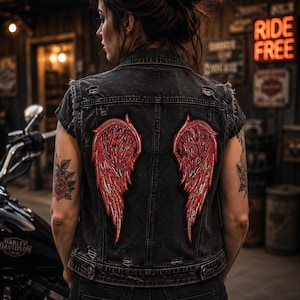 May include: A black denim waistcoat featuring two large, detailed red wing patches on the back. The waistcoat has a distressed finish with frayed armholes and a classic collar. The design is centred on the back panel, showcasing intricate feather textures.