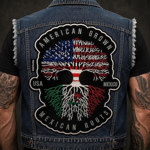 May include: A dark blue denim vest featuring a large embroidered patch on the back. The patch displays a tree with branches in the colors of the American flag and roots in the colors of the Mexican flag, with the text AMERICAN GROWN MEXICAN ROOTS.