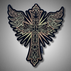 May include: Embroidered patch featuring a cross with stylized wings. The design incorporates intricate details in gold and cream thread on a black background. The text "WOLFCLAW.US" is visible on the lower right. This patch is suitable for jackets, bags, or other apparel.