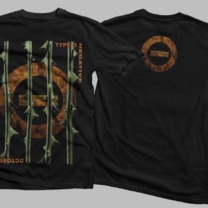 Könnte beinhalten: Schwarzes T-Shirt mit einem grafischen Druck eines Kreises mit einer horizontalen Linie, die ihn durchschneidet, umgeben von Dornen. Der Text "Type O Negative" und "October Rust" ist auf dem Shirt aufgedruckt. Die Rückseite des Shirts hat eine kleinere Version des Kreis-Grafik.