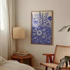 May include: A blue and white floral print art print with a wooden frame. The print features a variety of flowers and leaves in a stylized design.