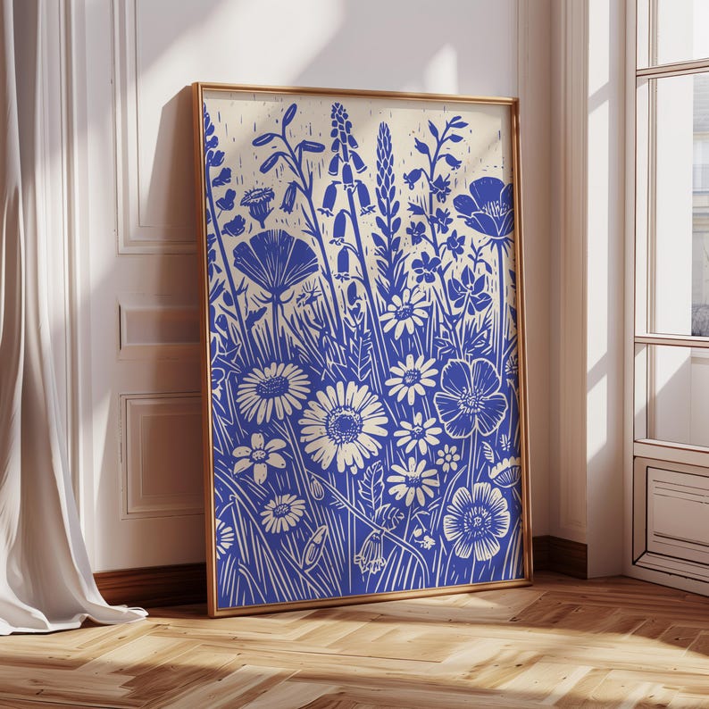 May include: A blue and white floral print art print in a gold frame. The print features a variety of flowers and leaves in a stylized design.