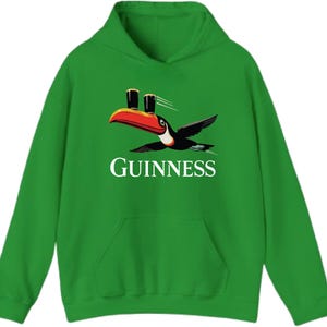 May include: Green hooded sweatshirt featuring a toucan carrying two pints of Guinness. The toucan has a red, orange, and black beak and wings. The word "GUINNESS" is printed in white below the bird.