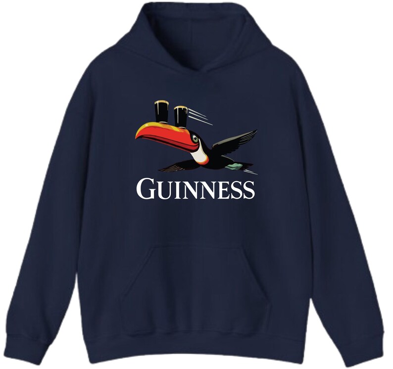 May include: Navy blue hooded sweatshirt featuring the Guinness logo with a toucan carrying two pints of beer. The toucan has a red, orange, and black beak and is in flight. The word "GUINNESS" is printed in white.