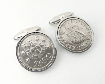 May include: A pair of silver cufflinks featuring Portuguese coins. One cufflink shows the coat of arms of Portugal, the other shows a ship with the text "REPUBLICA PORTUGUESA 1969".