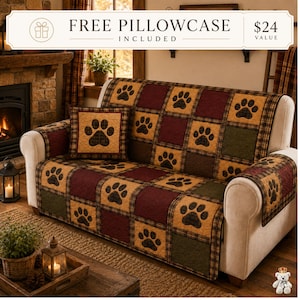 May include: A quilted sofa cover featuring a grid pattern of alternating squares in burgundy, olive green, and tan, each decorated with a black paw print. The cover includes a matching square throw pillow with a central black paw print design.