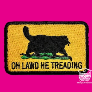 Könnte beinhalten: Ein gestickter Aufnäher in Gelb und Schwarz mit einer schwarzen Katzensilhouette und dem Text "OH LAWD HE TREADING".