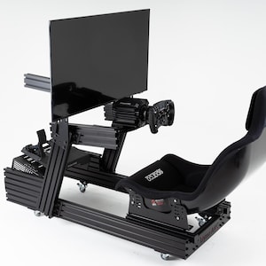 Pode incluir: Simulador de corrida preto com um assento de corrida preto, um volante preto e uma tela de televisão preta montada em uma moldura preta. O simulador está sobre rodas e tem uma base preta.