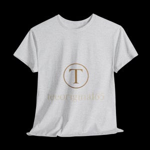Camiseta con logotipo dorado sobre fondo negro, elegante fuente serif, diseño de marca clásico, diseño lujoso e identidad de marca atemporal.